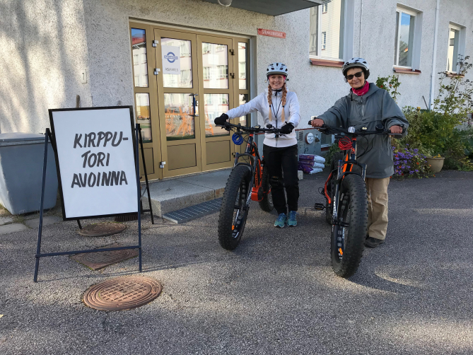Kunnan liikunnanohjaaja Elisa Pääkkönen opastaa Ristijärvellä vierailevaa Amie Aaltoa sähköavusteisen maastopyörän käytössä.